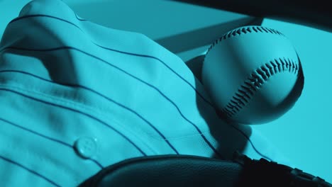 Close-Up-Studio-Baseball-Still-Life-With-Ball-Catchers-Mitt-And-Team-Jersey-With-Blue-Lighting